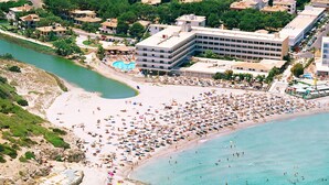 Una playa concurrida, con muchos sombrillas y gente.