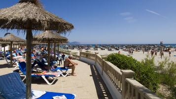 Een buitenzwembad, parasols voor strand/zwembad