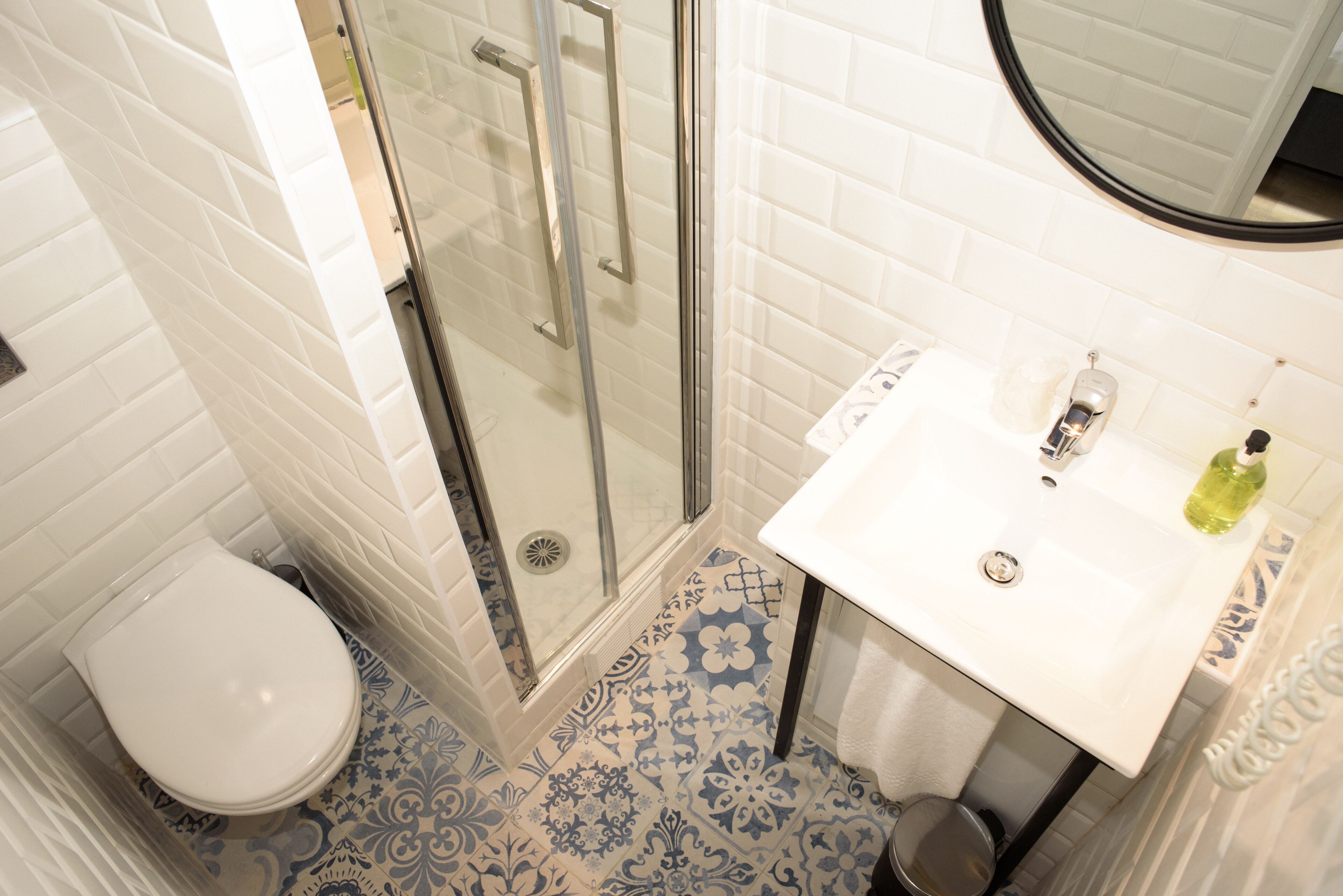 A bathroom with a white toilet, a glass-enclosed shower, and a sink with a mirror above it.