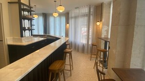Una cocina moderna con una isla central, taburetes de bar e iluminación colgante.