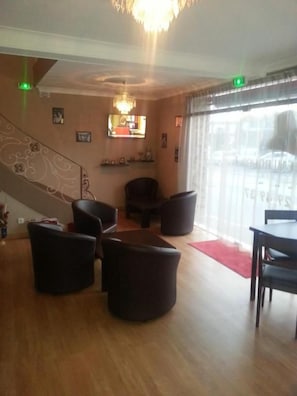 Un vestíbulo de hotel con una escalera, zona de estar y vistas a través de grandes ventanales.