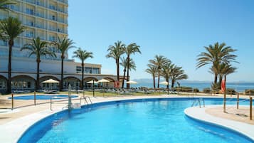 Una piscina al aire libre, tumbonas