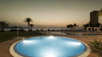 Alberca al aire libre y camastros