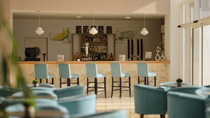 A bar area with a counter, chairs, and a shelf with bottles. - Aluasun Doblemar (San Javier)