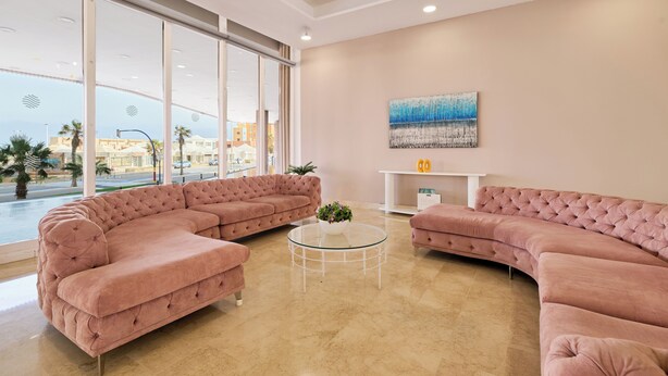 A modern living room with a sectional sofa, a glass coffee table, and a painting on the wall. - Aluasun Doblemar (San Javier)