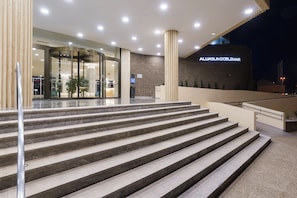 A hotel entrance with a curved staircase leading to a reception area. - Aluasun Doblemar (San Javier)