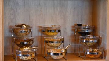 Montaje de bufé con múltiples recipientes de vidrio sobre soportes metálicos, cada uno con diferentes alimentos.