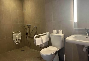 A bathroom with a toilet, sink, and shower area.