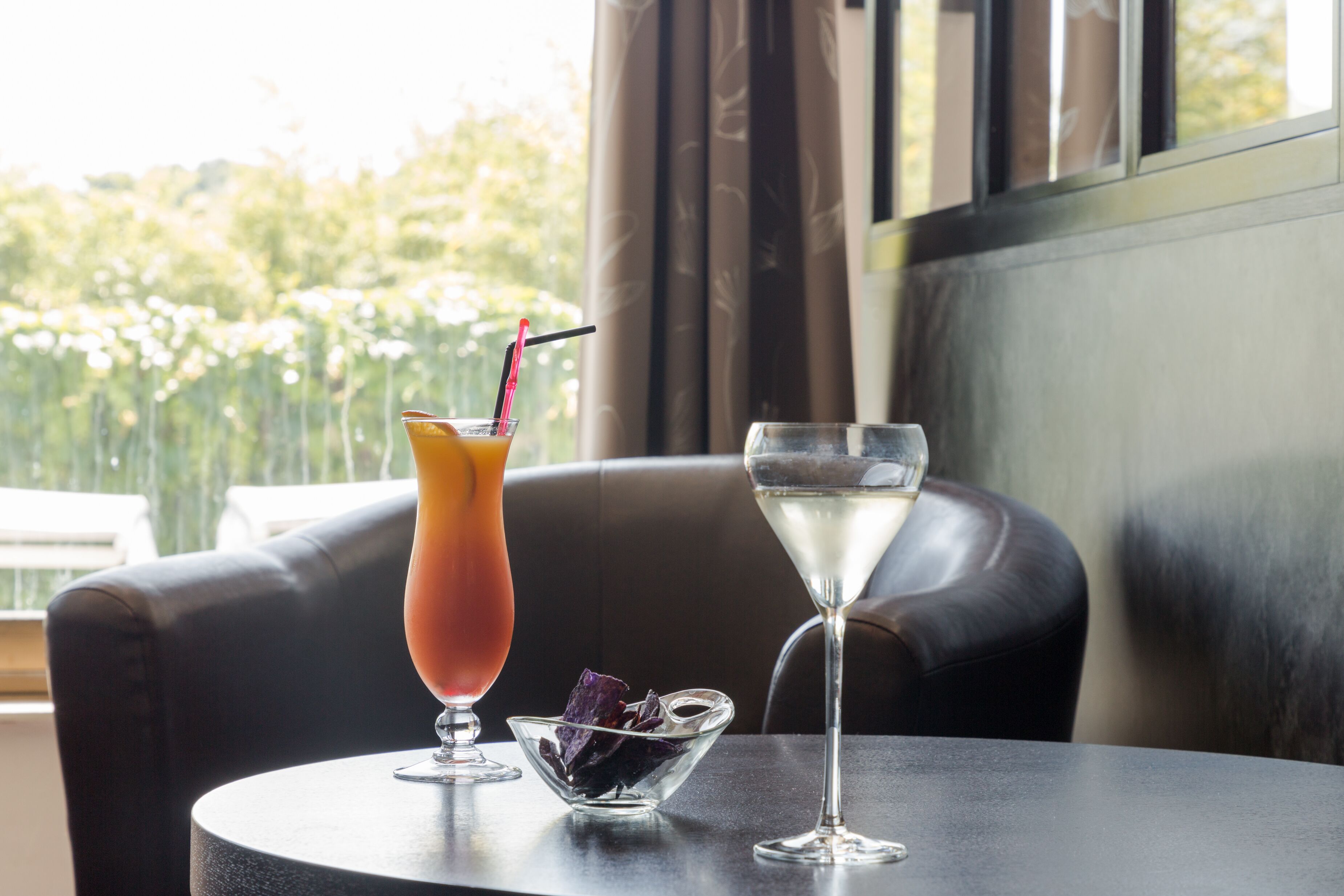 A table with two drinks and a small bowl of berries.