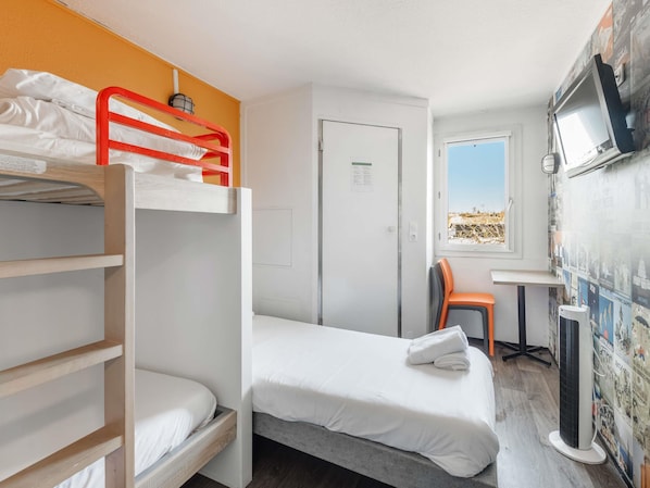Una habitación con una cama litera, una cama individual, un escritorio con silla, un televisor y una pared decorada con carteles.