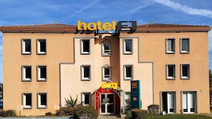 A hotel building with a clear sky, a sign reading 'hotel', and a price sign indicating '50€'. - hotelF1 Lyon Bourgoin-Jallieu (L'Isle-d'Abeau)