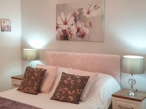 A bedroom with a bed, two nightstands, and a wall-mounted painting. - Abbeydale Hotel (Chesterfield)