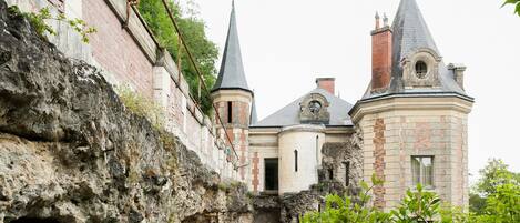 A historic building with a stone facade, a central tower, and two smaller towers.