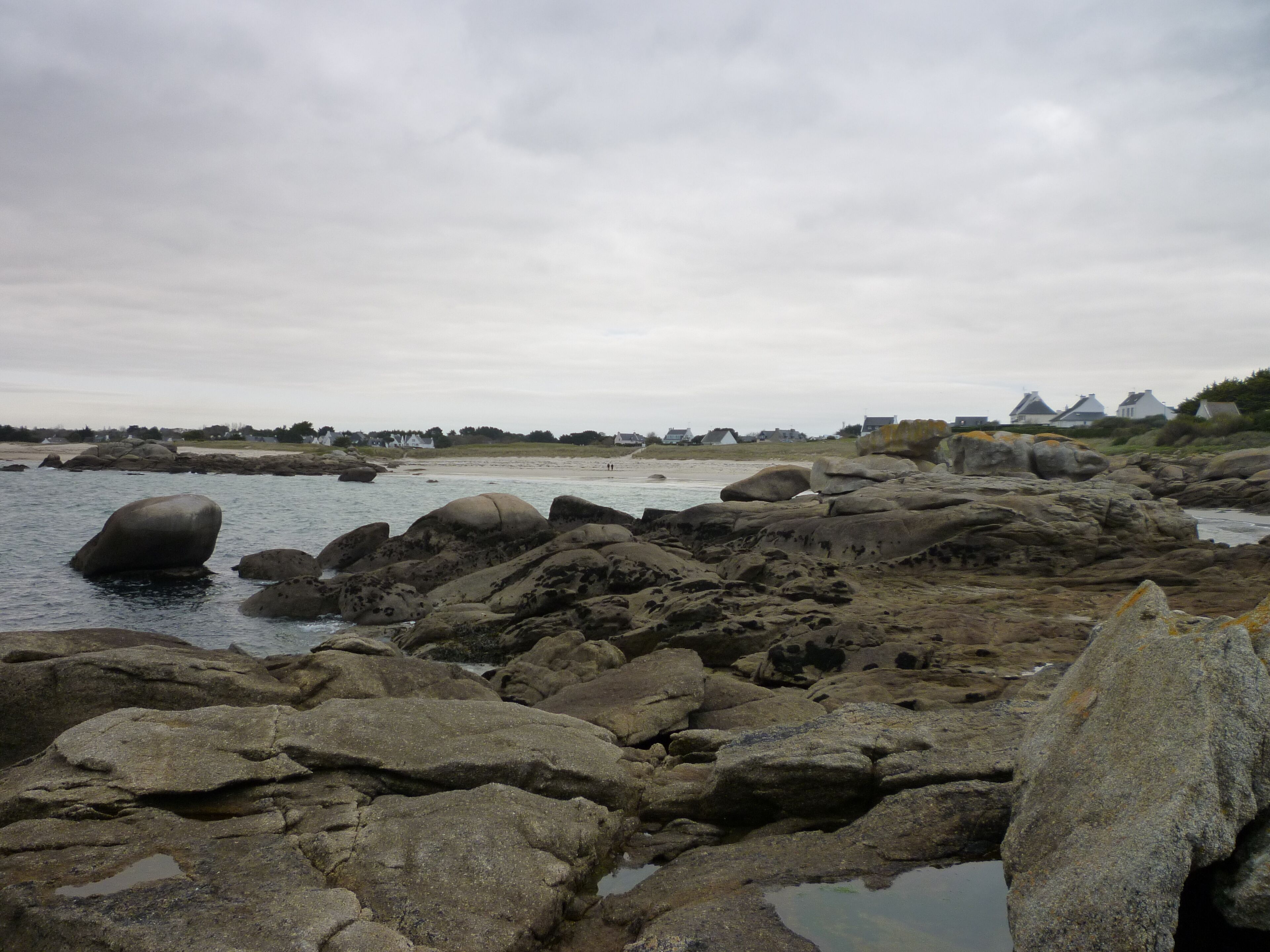Una costa rocosa con grandes rocas y agua tranquila.
