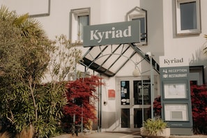 A reception area with a sign reading 'Kyriad' and a sign for a reception restaurant. -  Hôtel Kyriad Quimper Sud (Quimper)