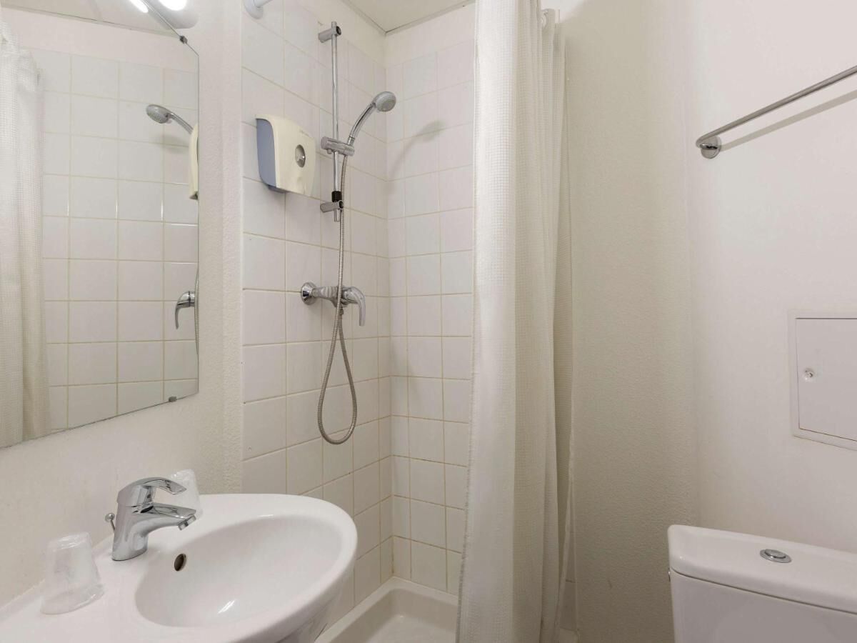 Un bagno con lavandino, specchio, doccia e WC.