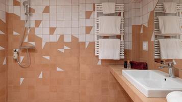 A bathroom with a shower, a sink, and a mirror.