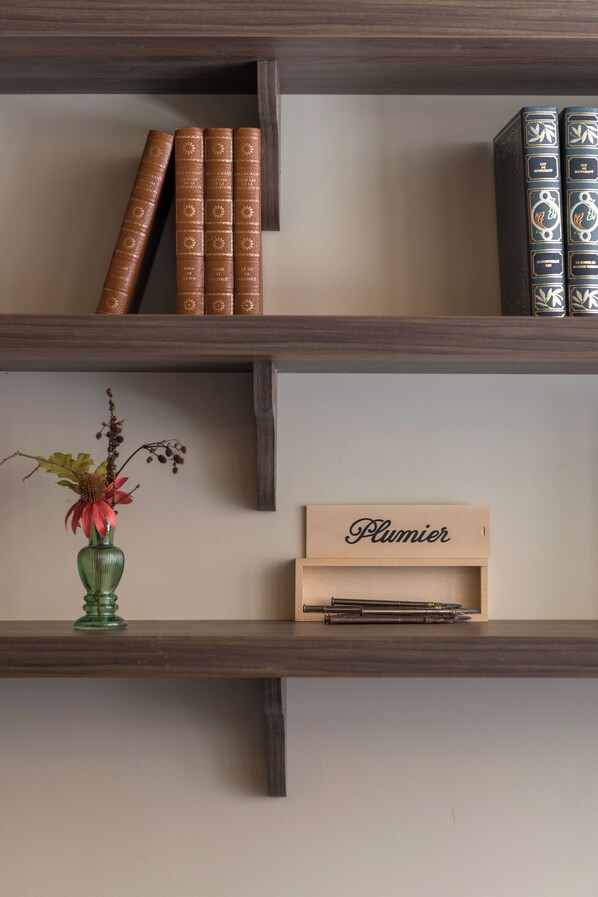 A wooden bookshelf with books and a small wooden box labeled "Plumier". - Académie Hôtel Lyon (Lyon)