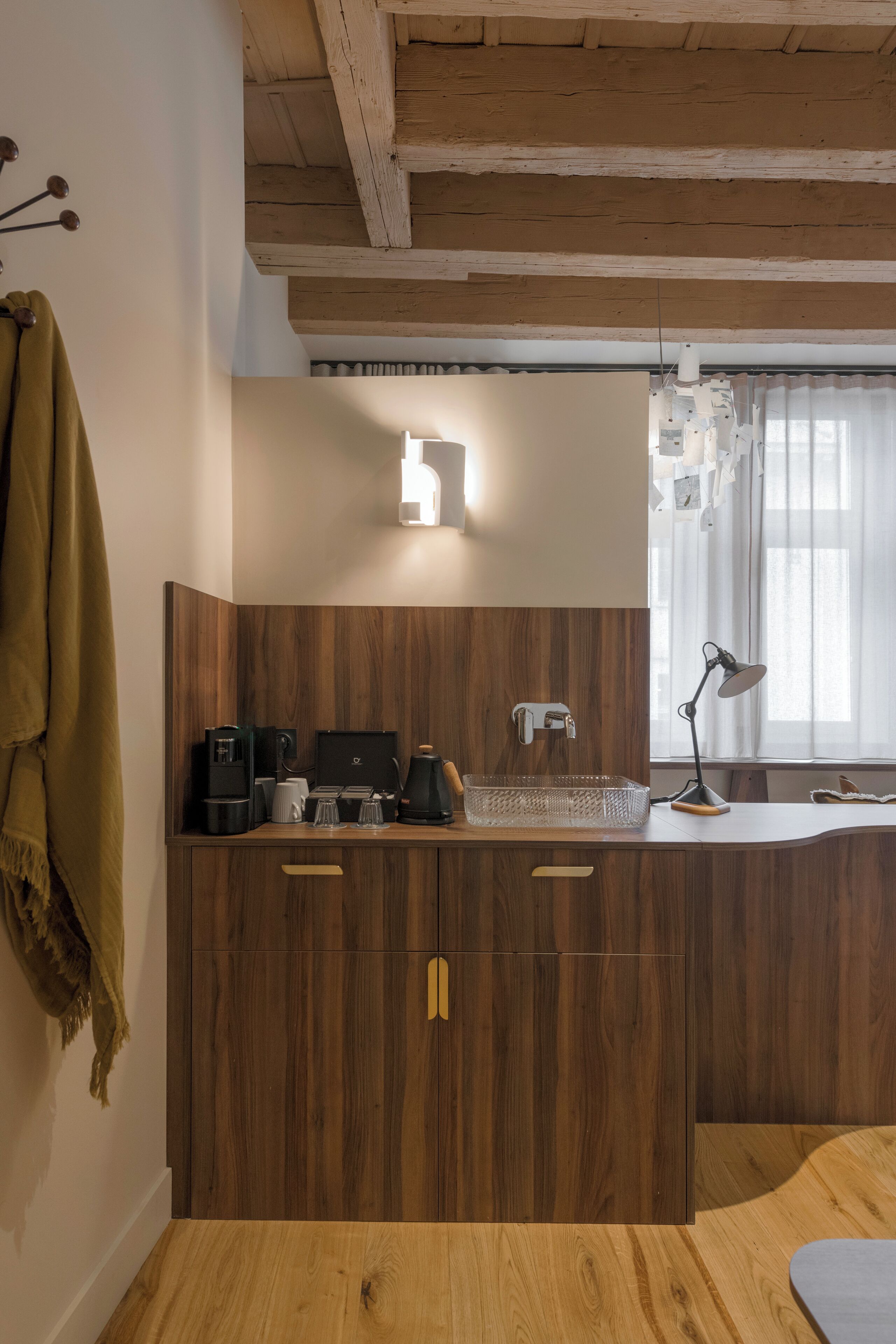 Una cocina de madera con una cafetera, un hervidor y otro hervidor en la encimera.