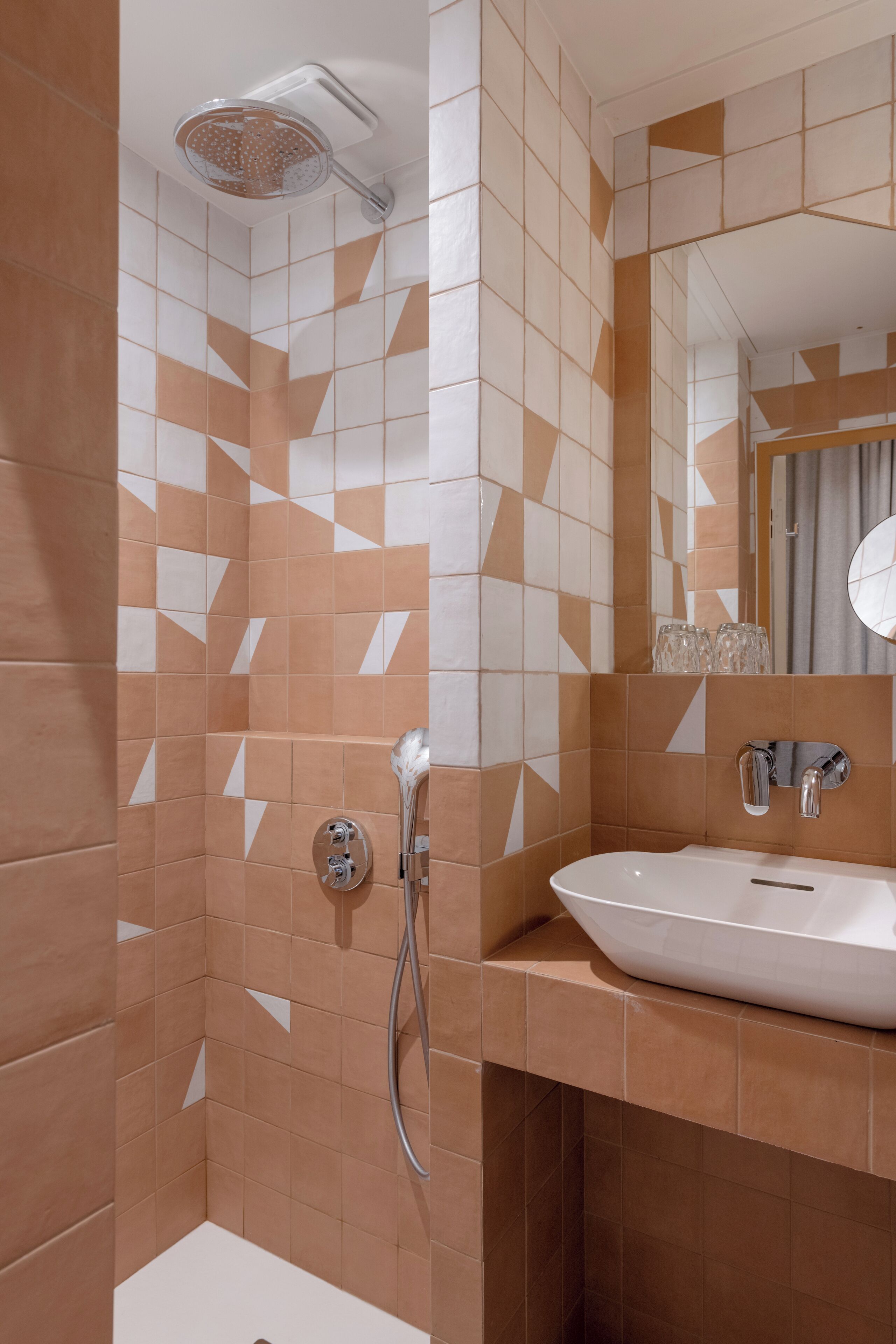 A bathroom with a shower, a sink, and a mirror.