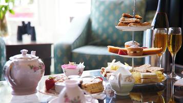 A tea service set with teacups, a sugar bowl, and a teapot on a table.