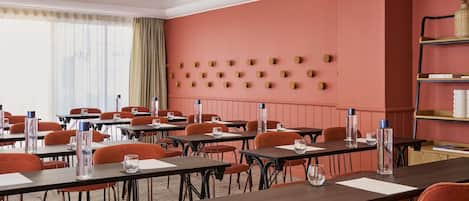 A conference room with tables, chairs, and a wall with circular decorations.