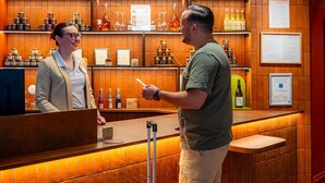 Un espace bar avec des lambris en bois, des étagères remplies de bouteilles et un comptoir.