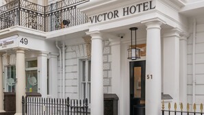 The exterior of the Victor Hotel with a flag, a balcony, and a sign indicating the hotel name. - Mornington Victor Hotel London Belgravia (London)