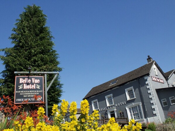 A hotel named Belle Vue Hotel with a signboard advertising bar meals, restaurant, accommodation, and sky sports. - Belle Vue Hotel (Llanwrtyd Wells)
