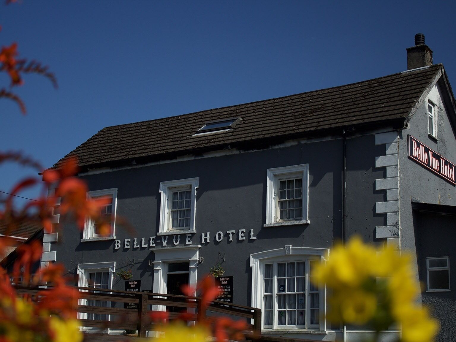 The Belle Vue Hotel with a classic facade, multiple windows, and a prominent sign.