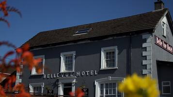 Hotel Belle Vue, con una fachada clásica, numerosas ventanas y un letrero llamativo.