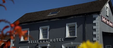 The Belle Vue Hotel with a classic facade, multiple windows, and a prominent sign.
