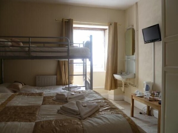 A bunk bed room with a window, a sink, and a television. - Belle Vue Hotel (Llanwrtyd Wells)