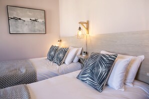 Habitación familiar, varias camas | Caja de seguridad en la habitación y ropa de cama