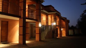 Un edificio de varios pisos con una escalera central, grandes pilares y un balcón en el nivel superior.