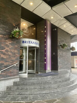 A reception area with a glass door entrance, a sign reading 'BRITANNIA', and a staircase leading up to the entrance. - Britannia Inn Glasgow (Glasgow)