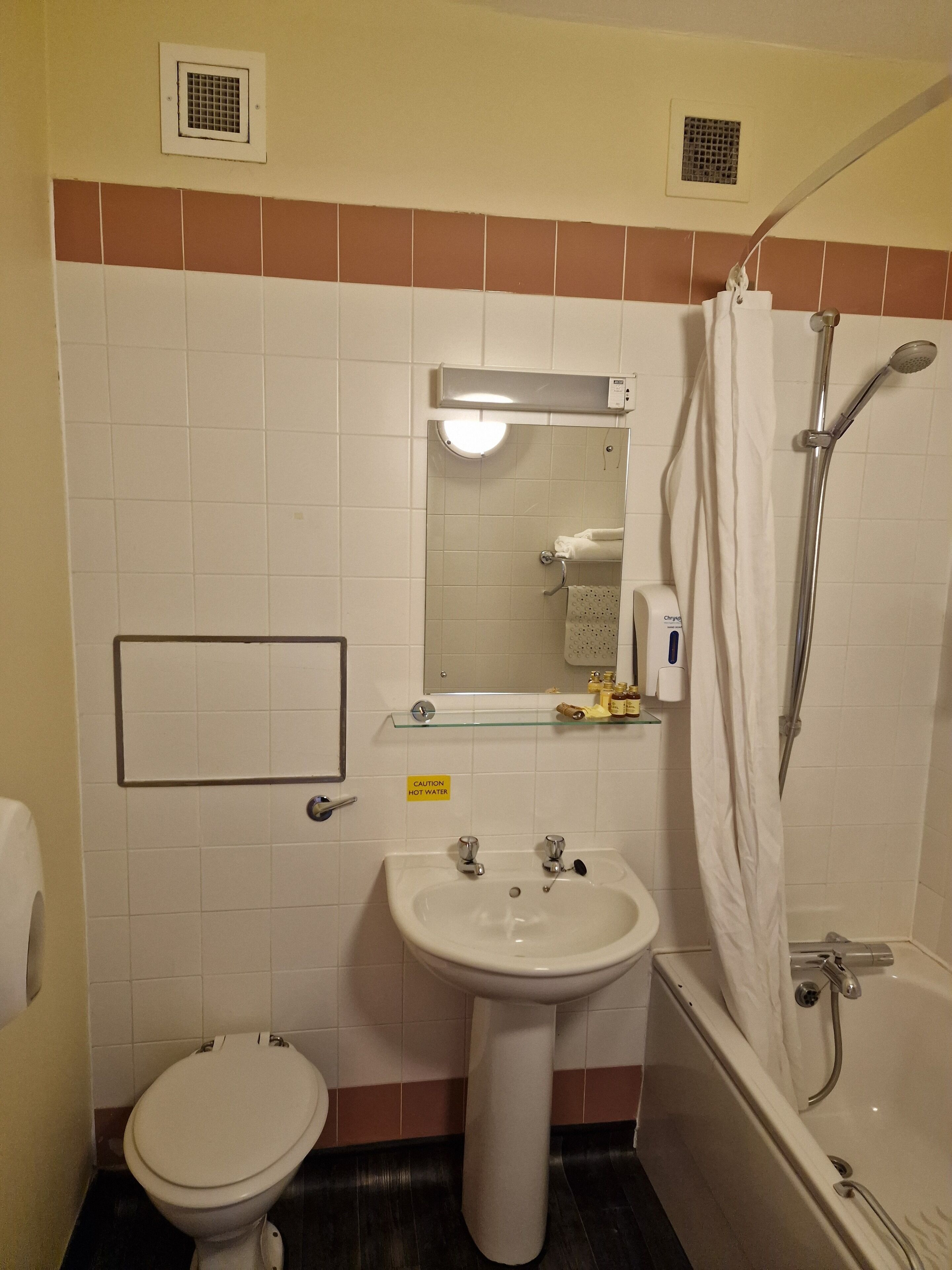 Un baño con inodoro, lavamanos y ducha.