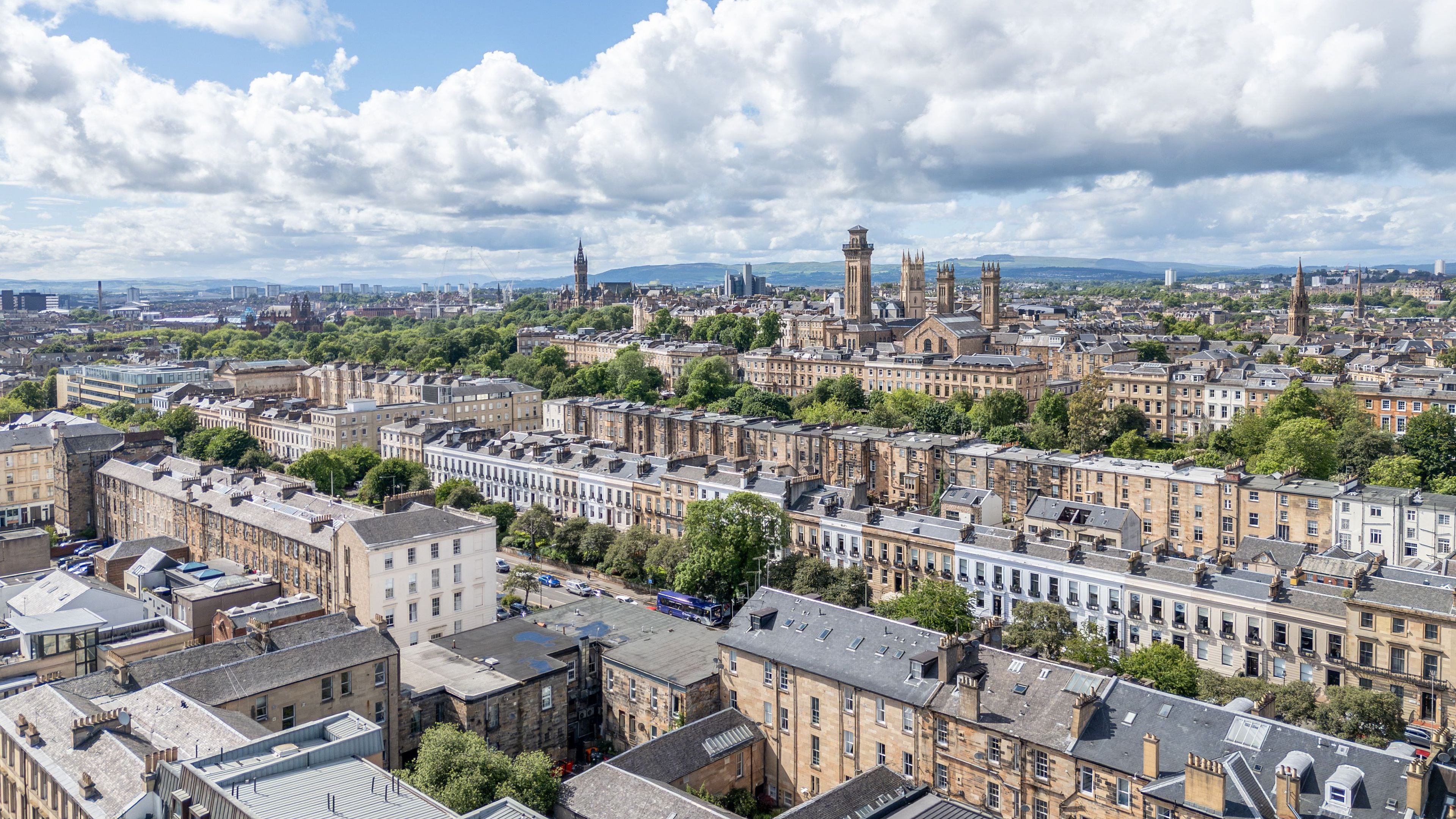 A cityscape with historic buildings, a prominent tower, and a clear sky.