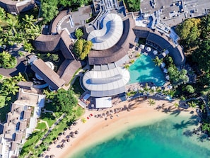 An aerial view of a resort with a central circular pool, multiple buildings, and a beach area. - LUX* Grand Gaube (Grand Gaube)