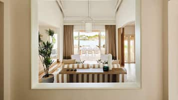 Una habitación amplia con un banco de madera, una mesa de comedor con sillas y vistas al exterior.