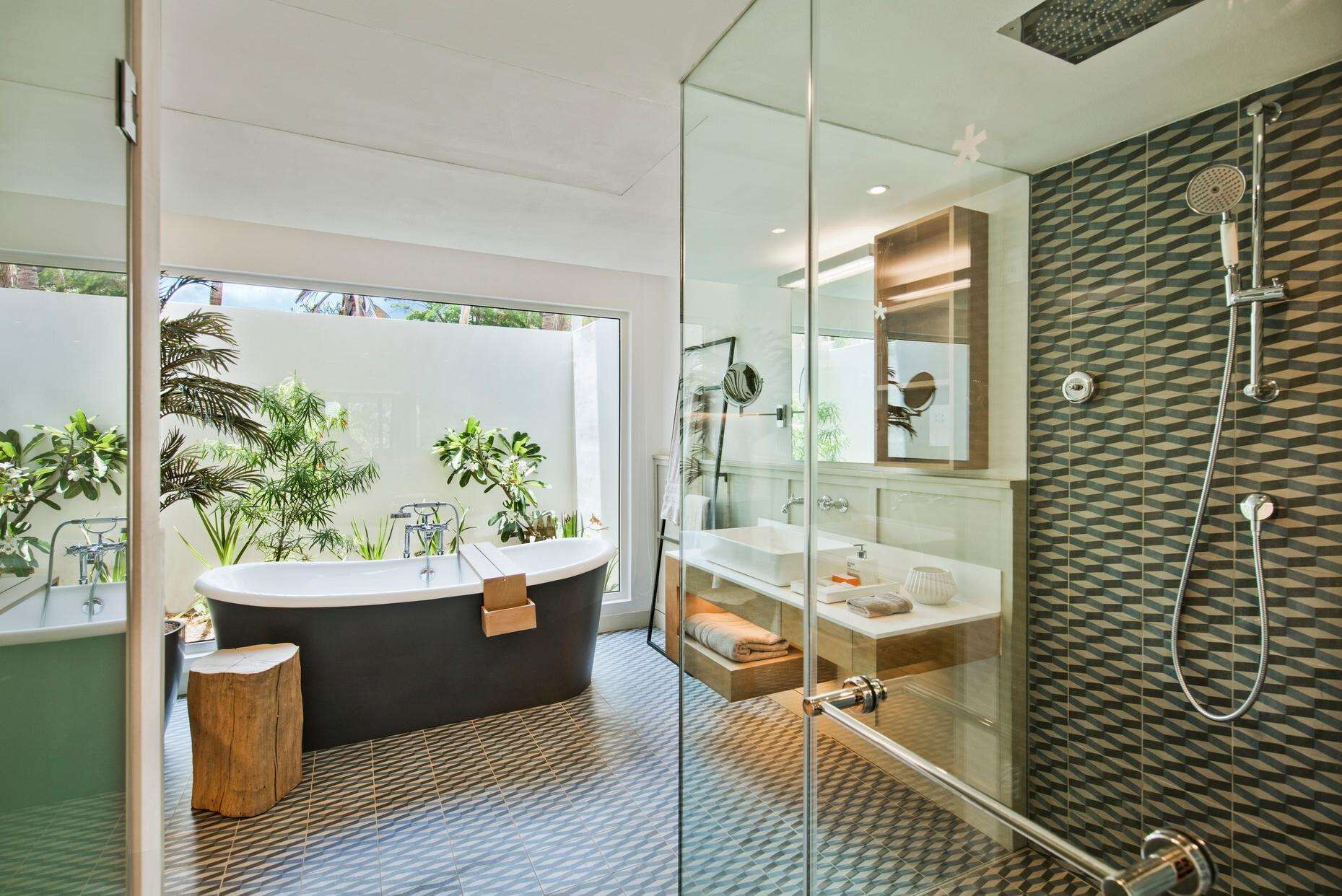 Un bagno moderno con una vasca freestanding, box doccia in vetro e un grande specchio.