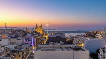 Un paisaje urbano al atardecer con una iglesia destacada y edificios residenciales.