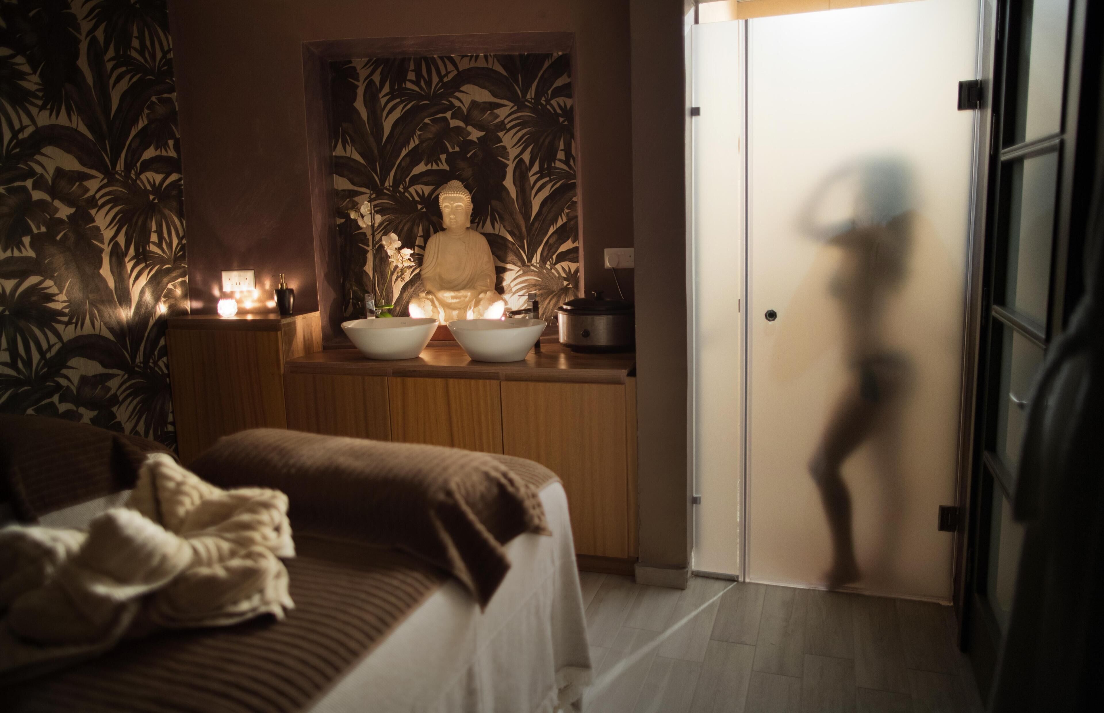 A room with a bed, a statue, and a door.