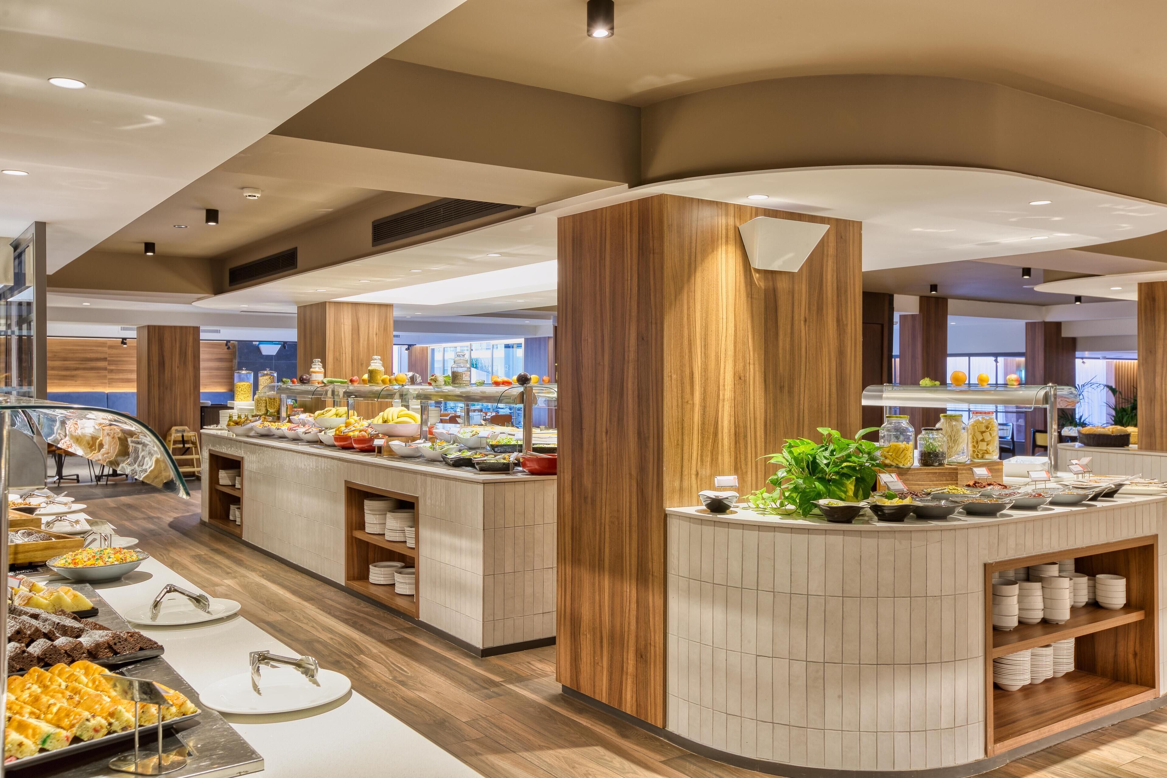 A buffet area with various food options, wooden paneling, and a modern design.
