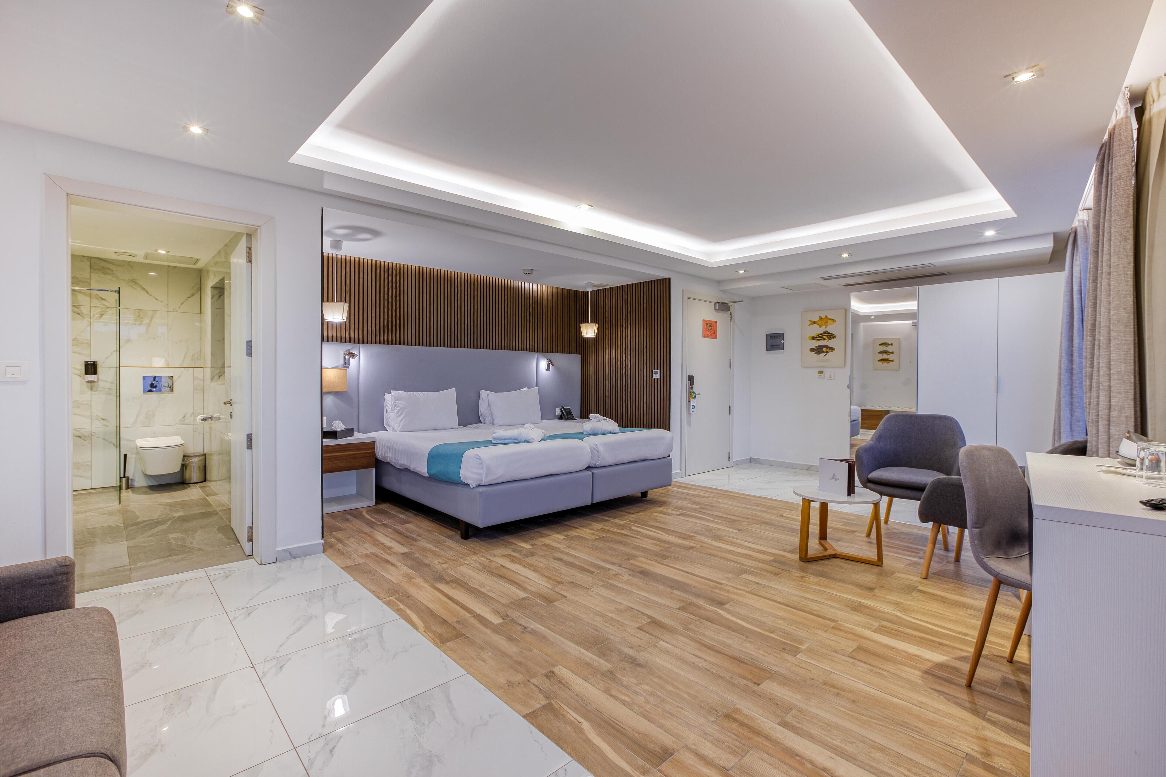 Een moderne hotelkamer met een groot bed, een bureau en een zithoek.