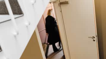 A staircase with a white railing and a door leading to another room.