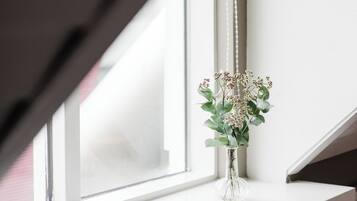 A clear view of a window with a vase of flowers on the sill.