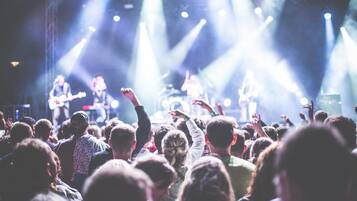 Un concerto con una folla che guarda una band sul palco.