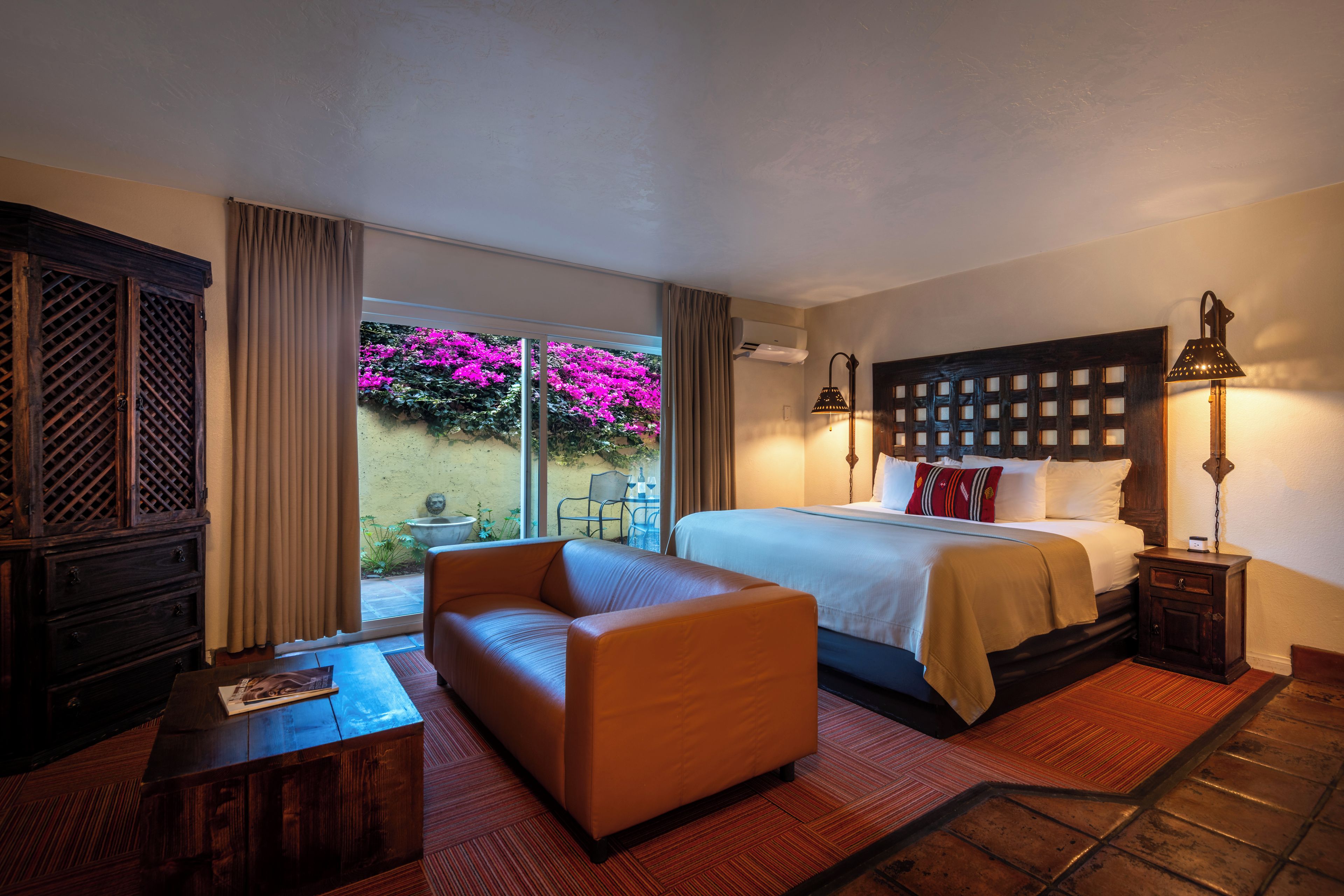 Ein Hotelzimmer mit einem Bett, einem Sofa, einem kleinen Tisch und einem Nachttisch.
