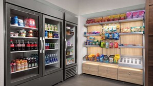 Et velassorteret dagligvareafsnit med kolde drikkevarer, snacks og emballerede varer.